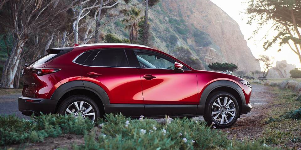 A red 2021 Mazda CX-30 parked in the forest.
