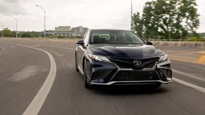 A blue 2022 Toyota Camry XLE shot from the front on a highway