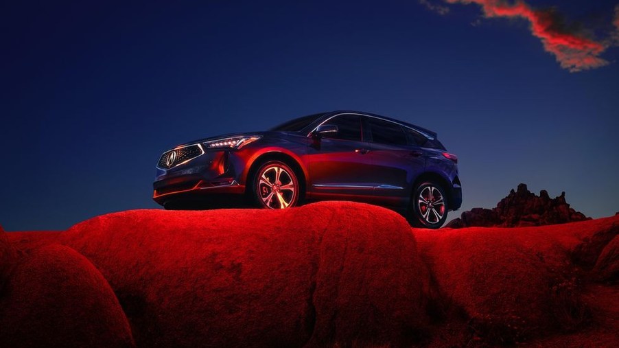 A blue 2022 Acura RDX parked outside on a cliff with red lighting