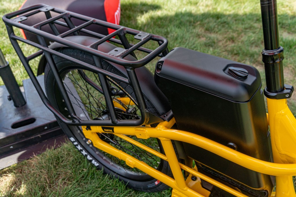 The black rear rack and lockable storage container on a yellow 2022 Momentum Pakyak E+