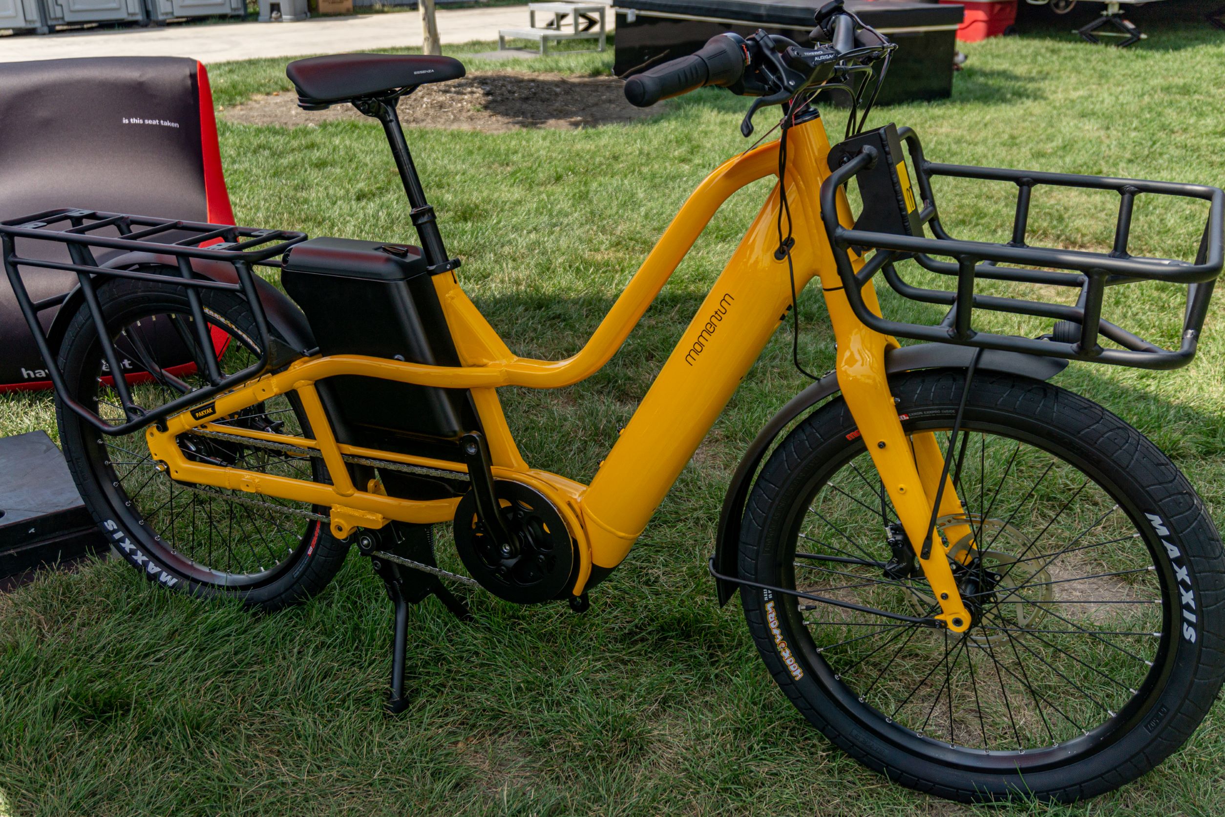 The right side view of a yellow-and-black 2022 Momentum Pakyak E+ under a canopy