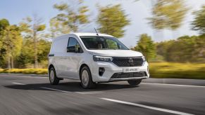 a white 2022 Nissan Townstar EV driving on a road during the day