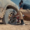 A man fixing a flat tire on the Rivian R1T