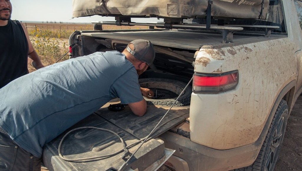 A man changing the tire on the new Rivian R1T