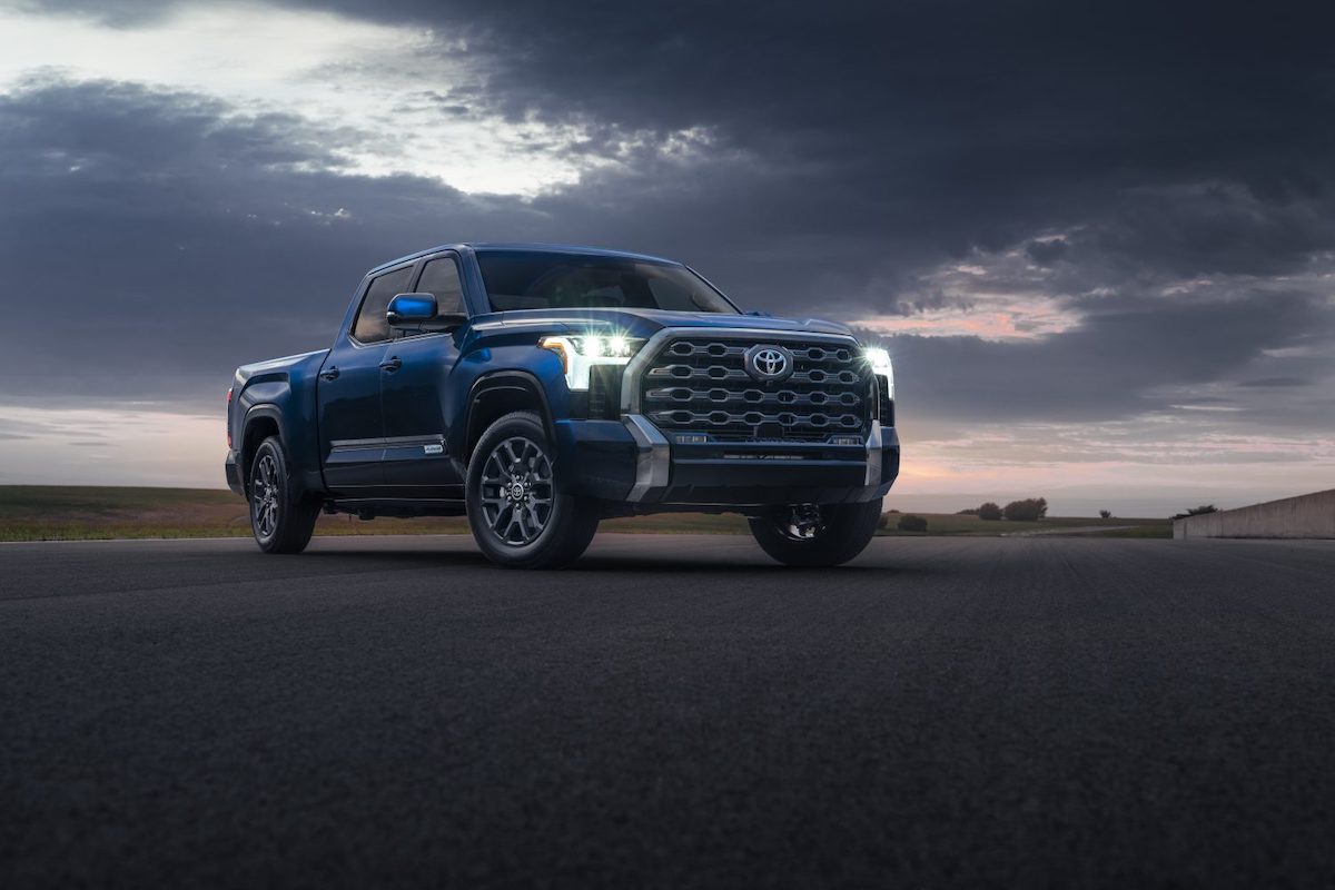A blue 2022 Toyota Tundra Platinum pickup truck parked on the pavement under a cloudy sky