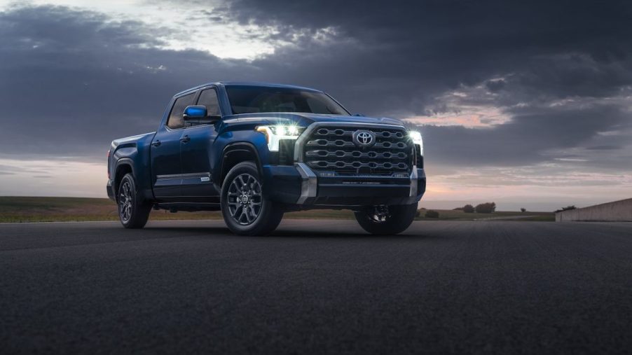 A blue 2022 Toyota Tundra Platinum pickup truck parked on the pavement under a cloudy sky
