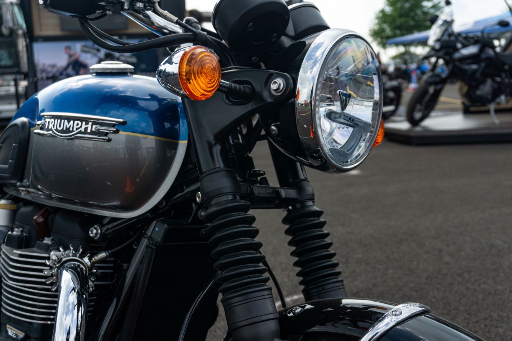 The headlight and forks of a blue-and-silver 2022 Triumph Bonneville T120