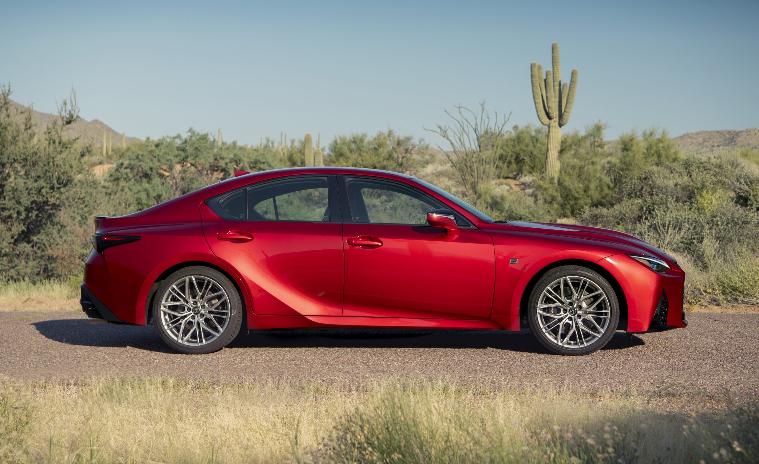 A red Lexus IS 500 shot in profile in the desert with cacti in the background