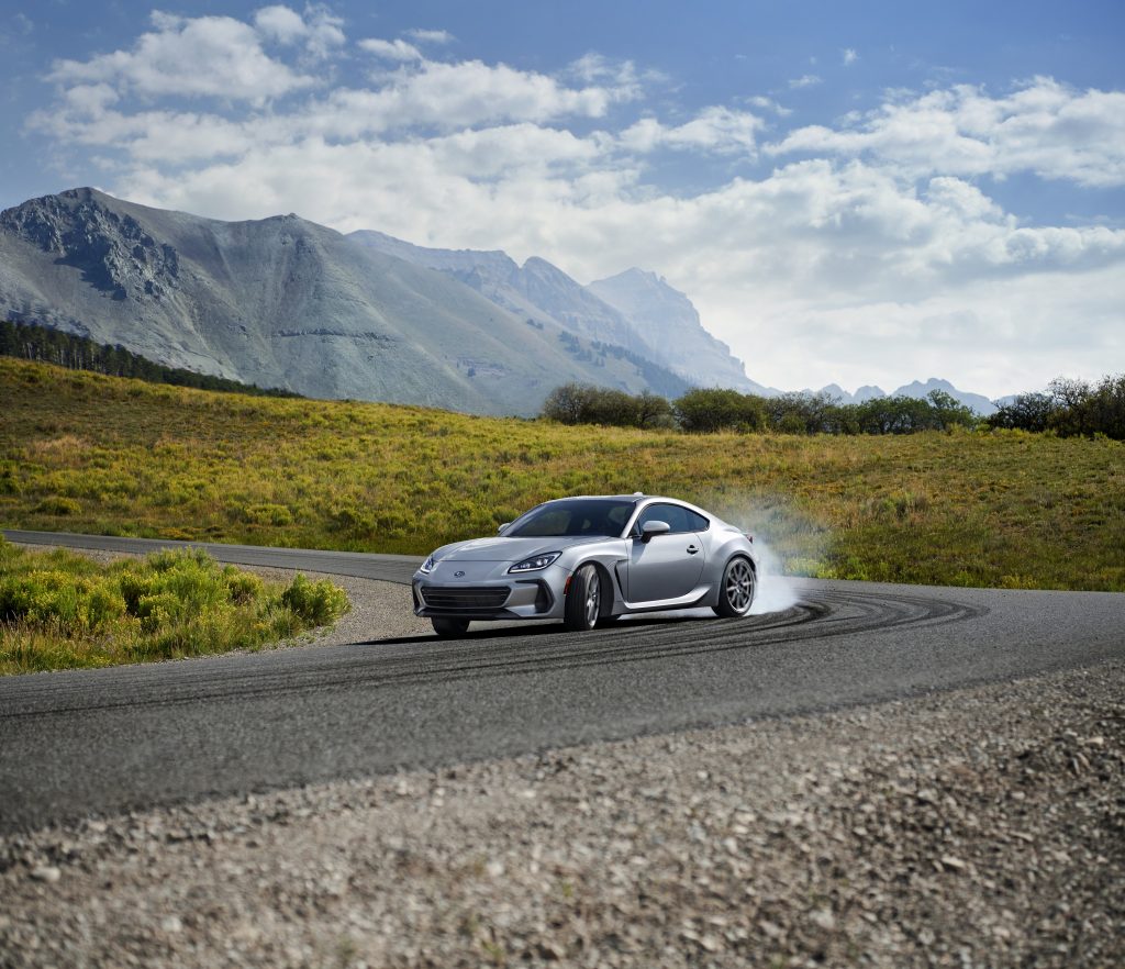 A silver 2022 Subaru BRZ slides it's way down a mountain pass kicking out tire smoke
