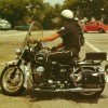 A Los Angeles police officer on a black-and-white Moto Guzzi Eldorado 850 police bike in a 1970s parking lot