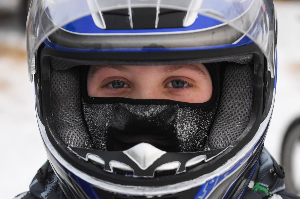 A Moto Skijoring competitor with a winter balaclava under their motorcycle helmet