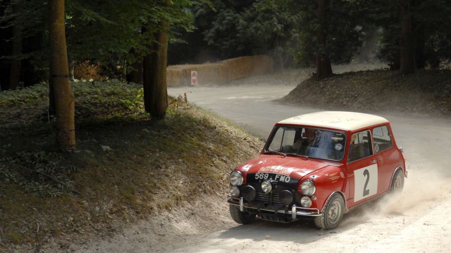 A classic red-and-white Austin Mini Cooper S drives around the 2009 Goodwood Festival of Speed Forest Rally Stage