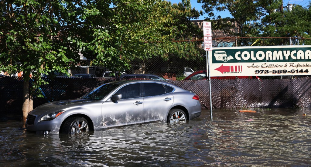 An abandoned car is seen in flooded waters.