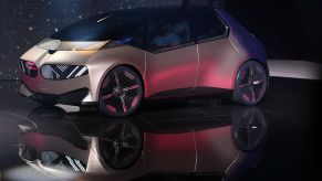 The BMW i Vision Circular on a black stage in front of a screen displaying stars in a night sky.