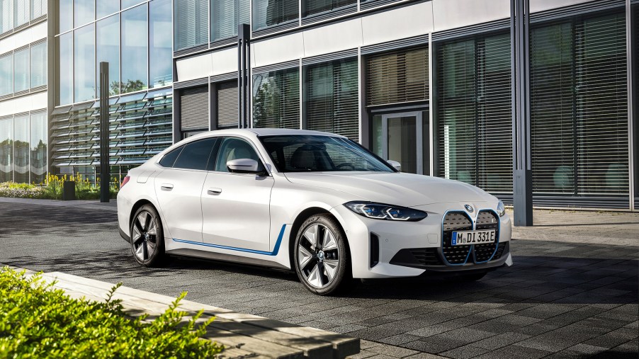 The BMW i4 electric sedan in white with blue accents along the lower sides of the car and around the front grilles.