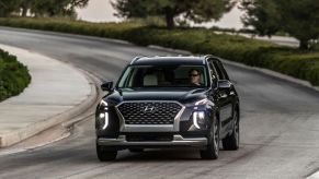 Black 2022 Hyundai Palisade driving on a curvy road