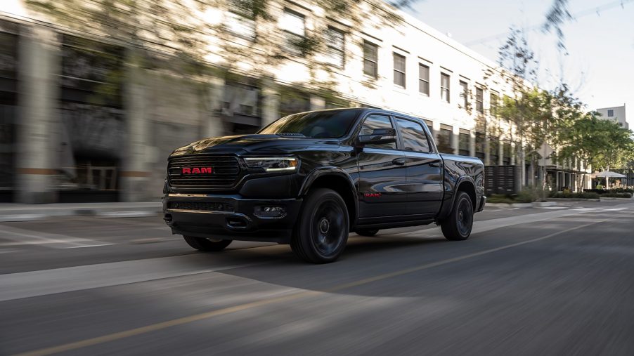 Black 2022 Ram 1500 Limited (RAM) RED Edition driving down a street