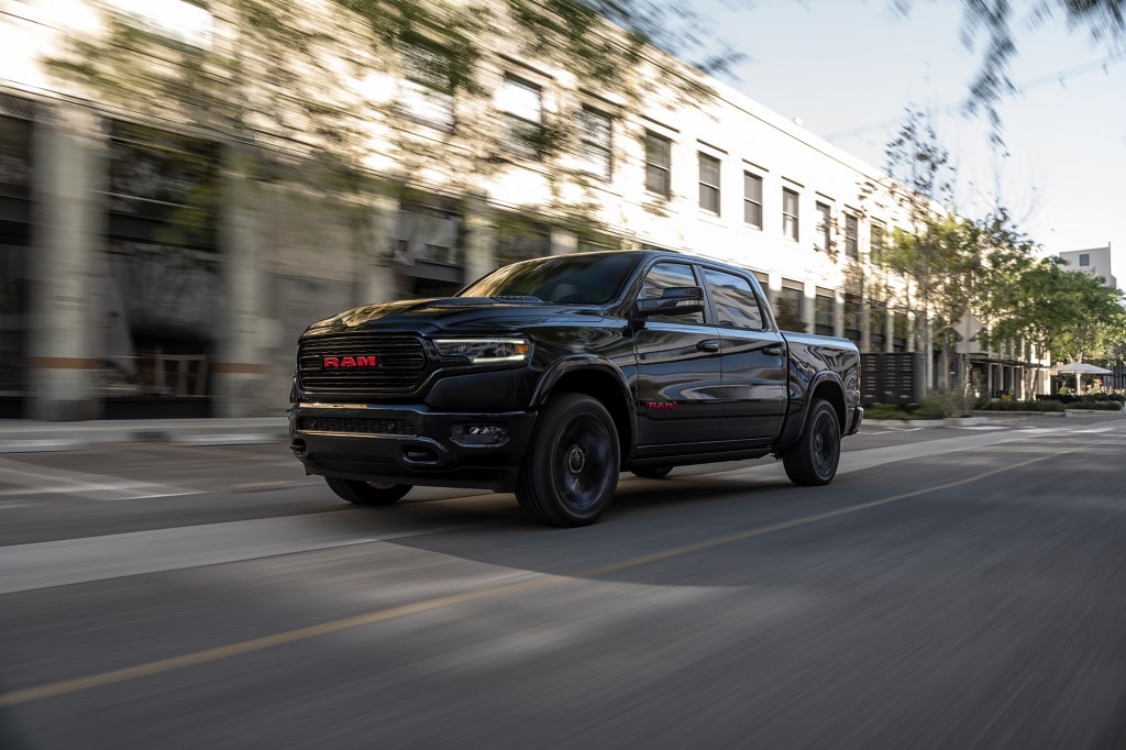 Black 2022 Ram 1500 Limited (RAM) RED Edition driving down a street