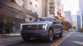 Blue 2022 Ford F-150 Lightning driving on a city street