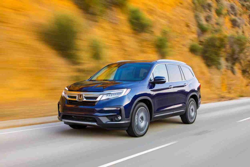 Blue 2022 Honda Pilot driving by a hill