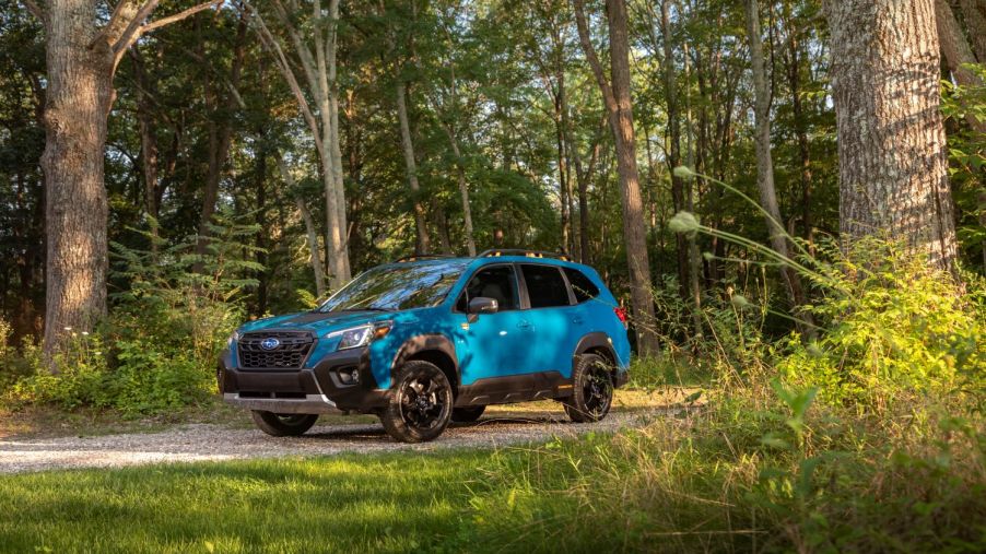 Blue 2022 Subaru Forester driving through a forest