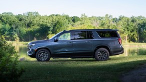 Blue-gray 2021 Chevrolet Suburban parked next to a lake