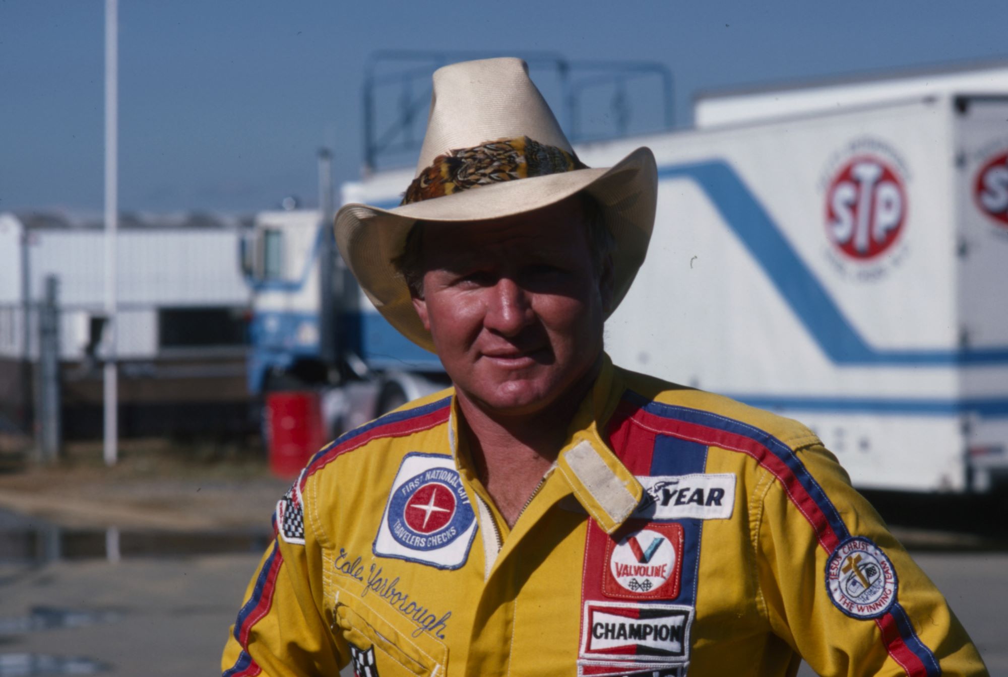 Cale Yarborough wearing a yellow shirt with carious branded patches.