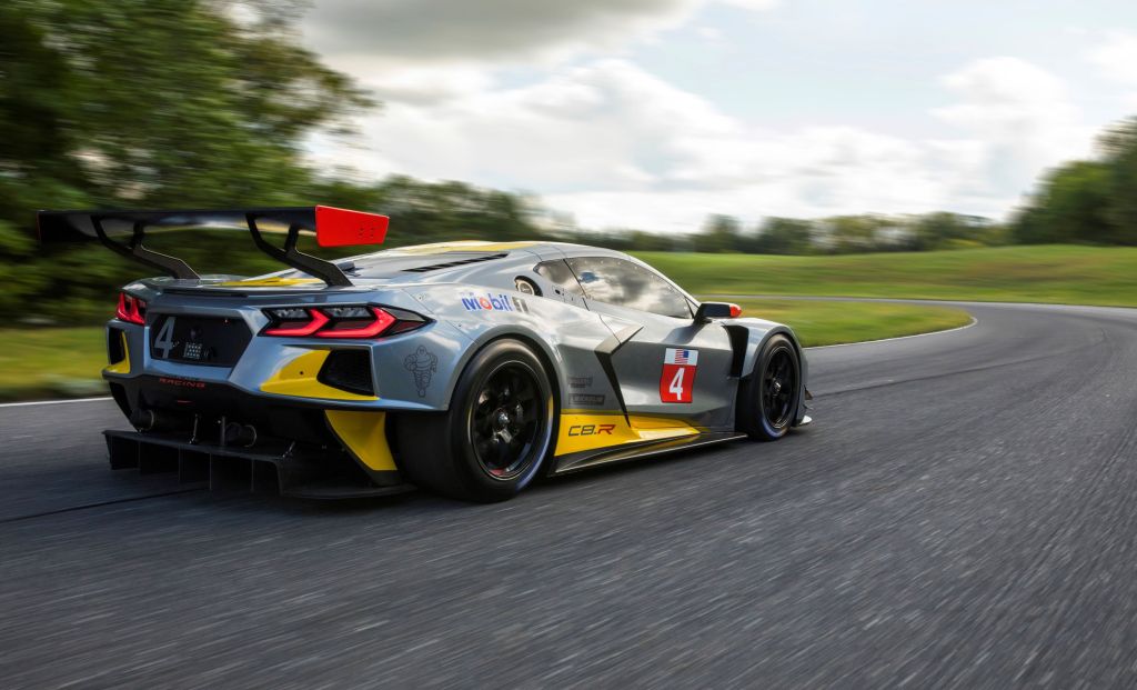 The rear 3/4 view of the gray-and-yellow Chevrolet Corvette C8.R on a racetrack
