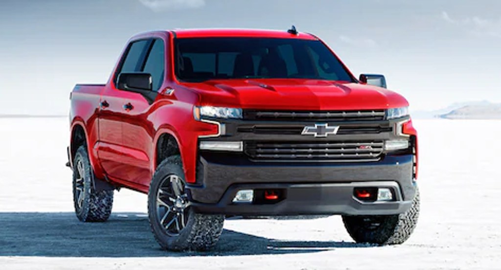 A red 2021 Chevrolet Silverado 1500 LT Trail boss is parked in ground lightly coated in snow. 