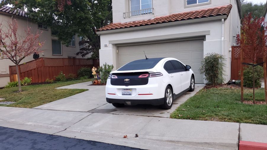 A Chevrolet Volt EV model parked outside the garage of a suburban home