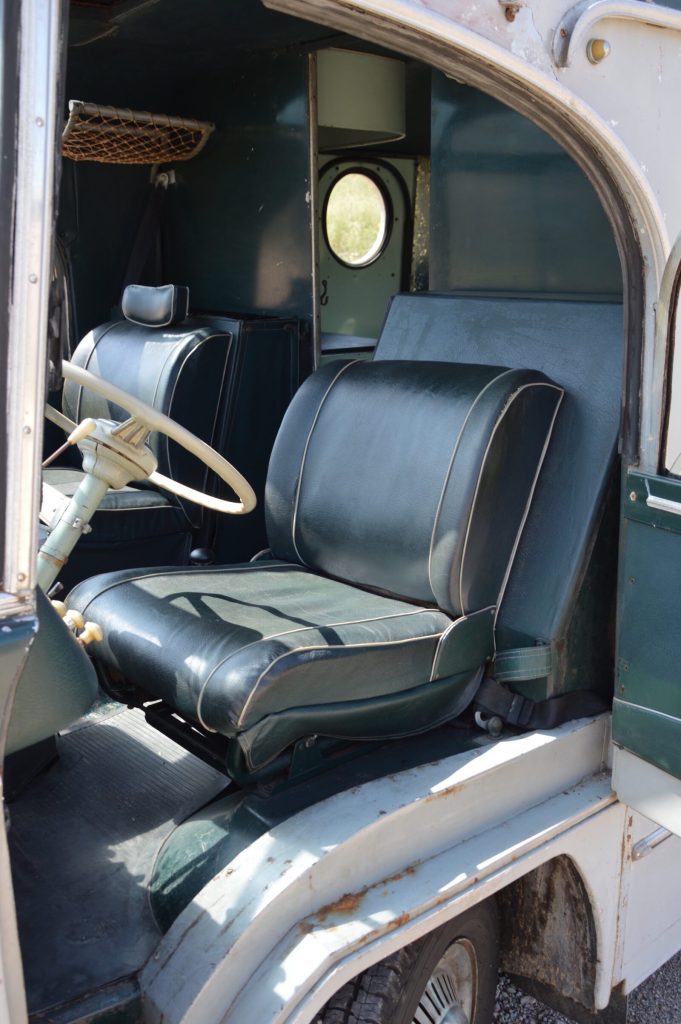 Driver's seat of the Custom H Van shows cool green vinyl seats and a cab over coxkpit
