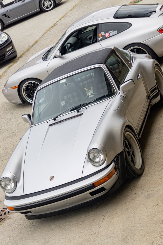 The overhead front 3/4 view of a silver classic Porsche 911 Targa in a parking lot