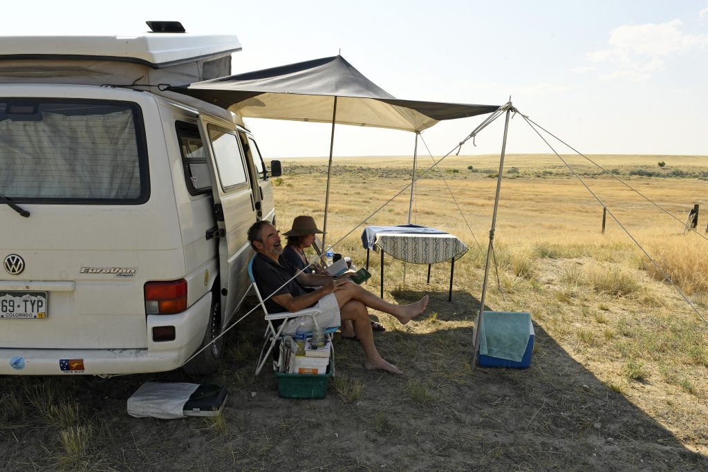 A Couple Sits Outside Their Volkswagen Camper Van