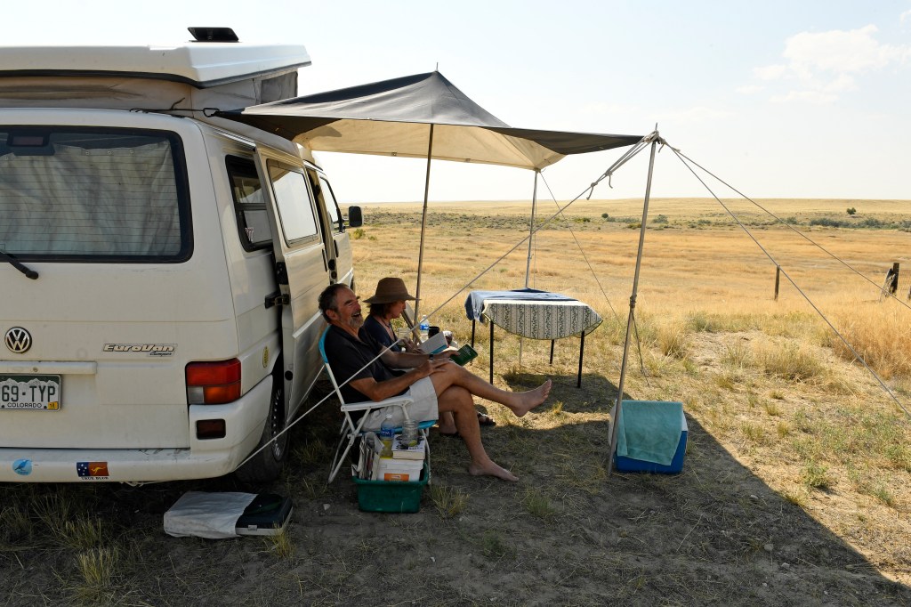 A Couple Sits Outside Their Volkswagen Camper Van