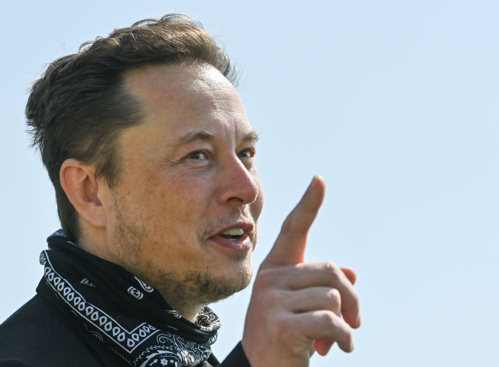 Creator of Tesla, Elon Musk dressed in black with a black handkerchief around his neck.
