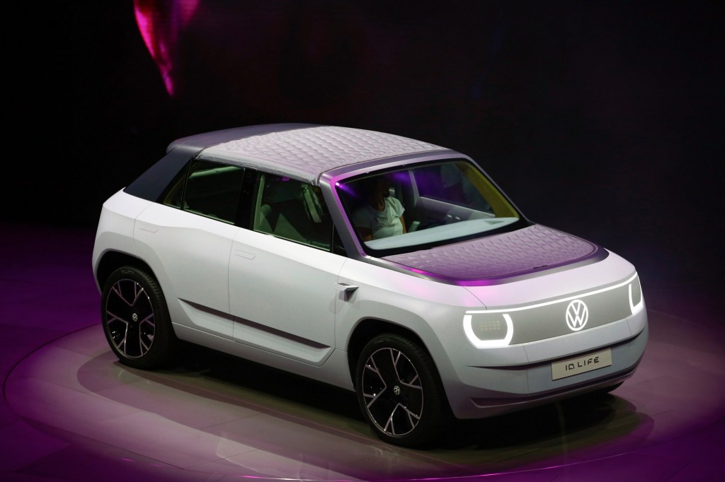 The ultra-minimalist white and grey Volkswagen ID.Life concept, shot from a high front 3/4 angle at the Munich Auto Show