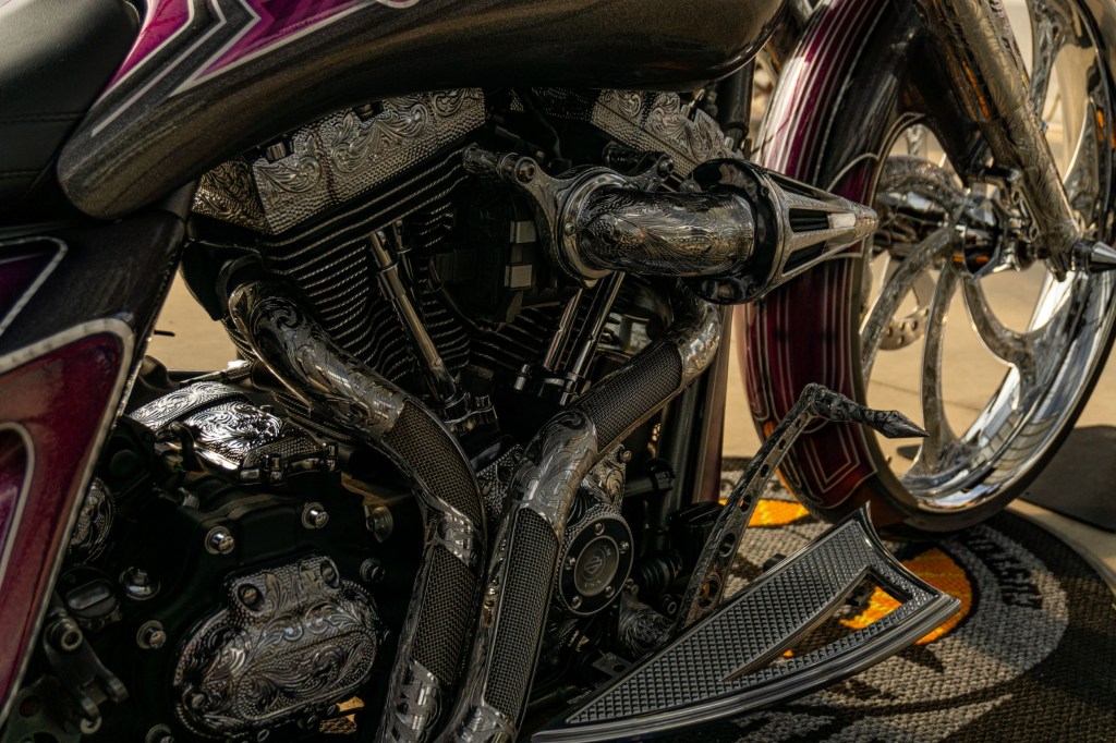 A close-up view of the metal filigree on David Moreno's custom purple-and-black 2013 Harley-Davidson Street Glide bike's V-twin engine