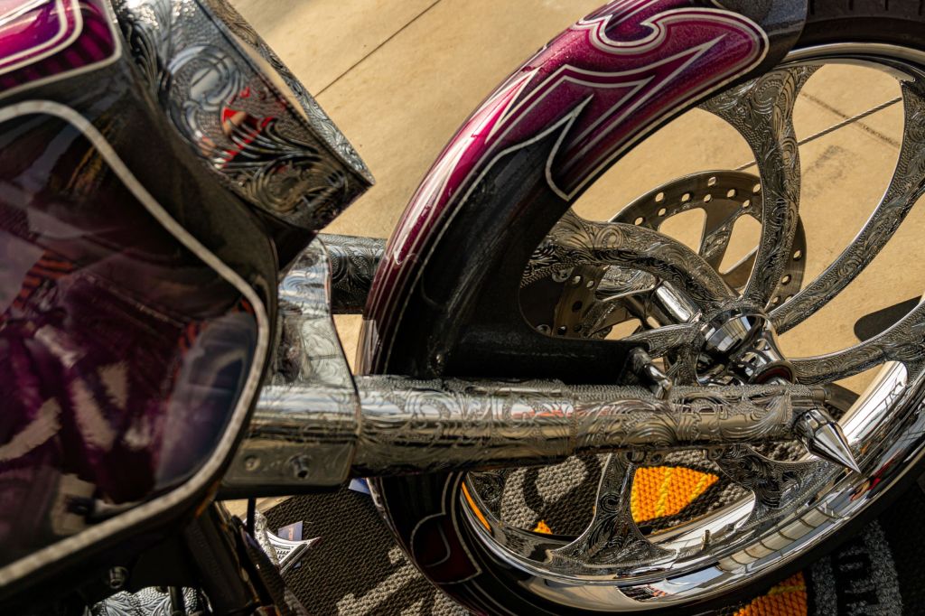 The engraved front forks and front wheel on David Moreno's custom purple-and-black 2013 Harley-Davidson Street Glide bike