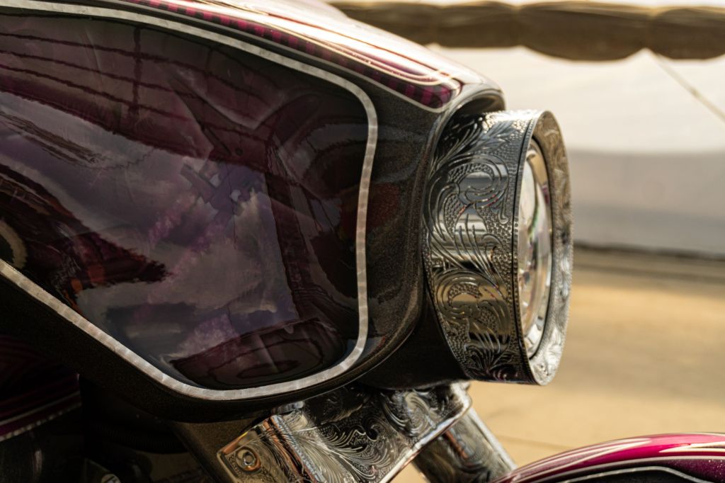 A close-up view of the engraved headlight on David Moreno's custom purple-and-black 2013 Harley-Davidson Street Glide