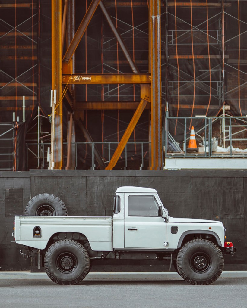 Brooklyn Coachworks' Land Rover Defender 110 1-ton parked infront of a construction site