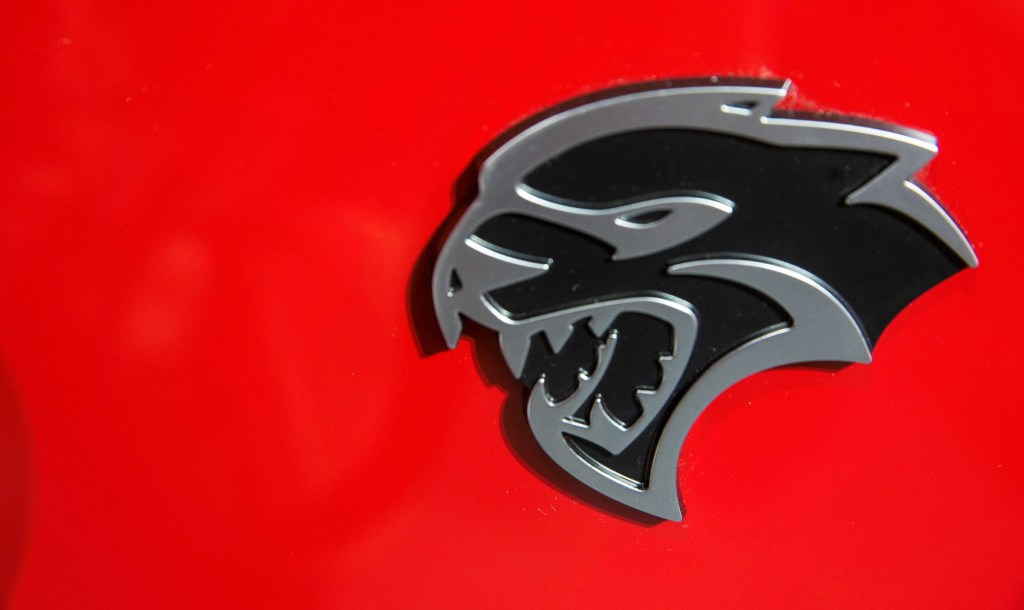 A Dodge Challenger Hellcat logo on a red car.