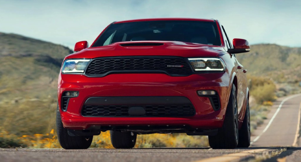 A red Dodge Durango SUV is driving on the road. 