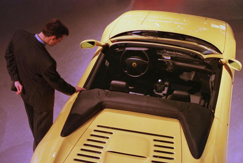 A passerby looks at a Ferrari F355 Spider at the 1998 North American International Auto Show in Detroit
