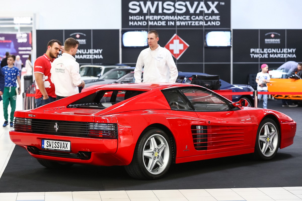 A red Ferrari Testarossa seen at a car show in Warsaw. The view is from the rear quarter of the car. It is similar to the Ferrari used in the drag race featured in this article.