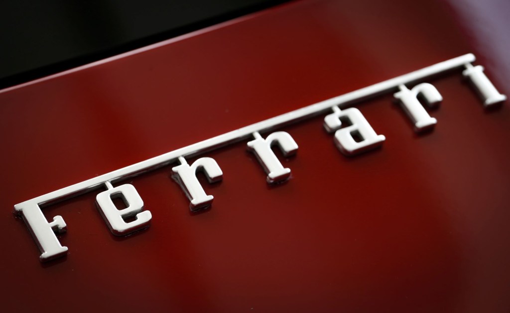 Ferrari logo for Ferrari price guide on a red car with Ferrari written in Chrome.