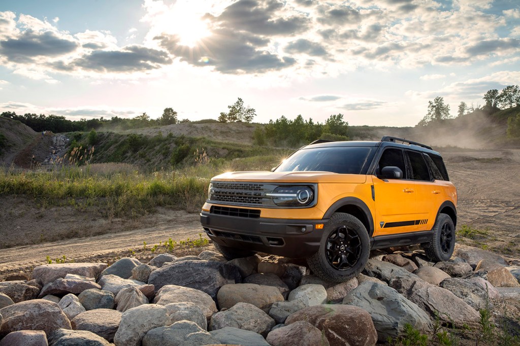 2021 Ford Bronco Sport in Cyber Orange color is driving over rocks.