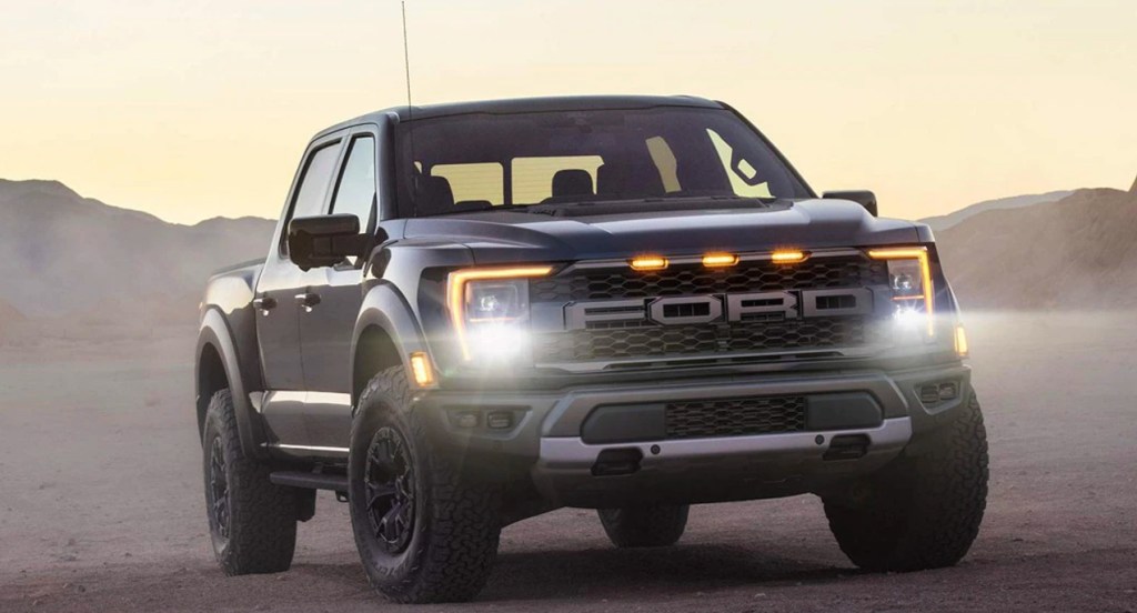 A black Ford F-150 Raptor off-road truck is parked. 