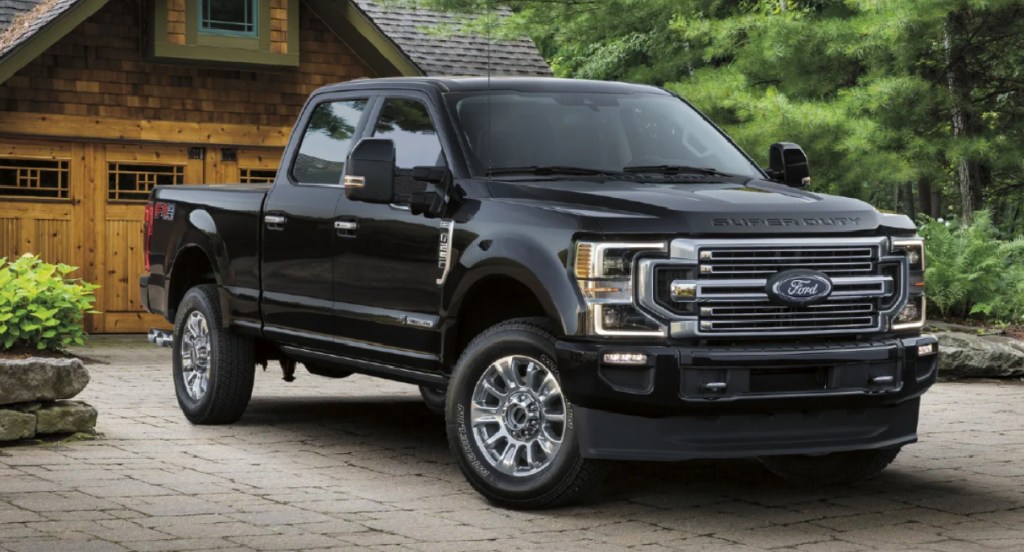 A black Ford F-250 Super Duty pickup truck is parked outside of a home. 