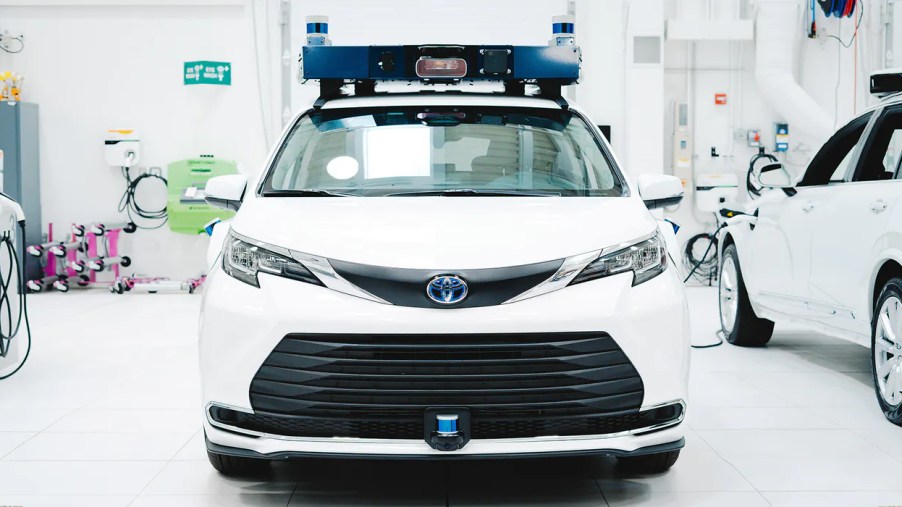 Front view of white Aurora Toyota Sienna self-driving taxi