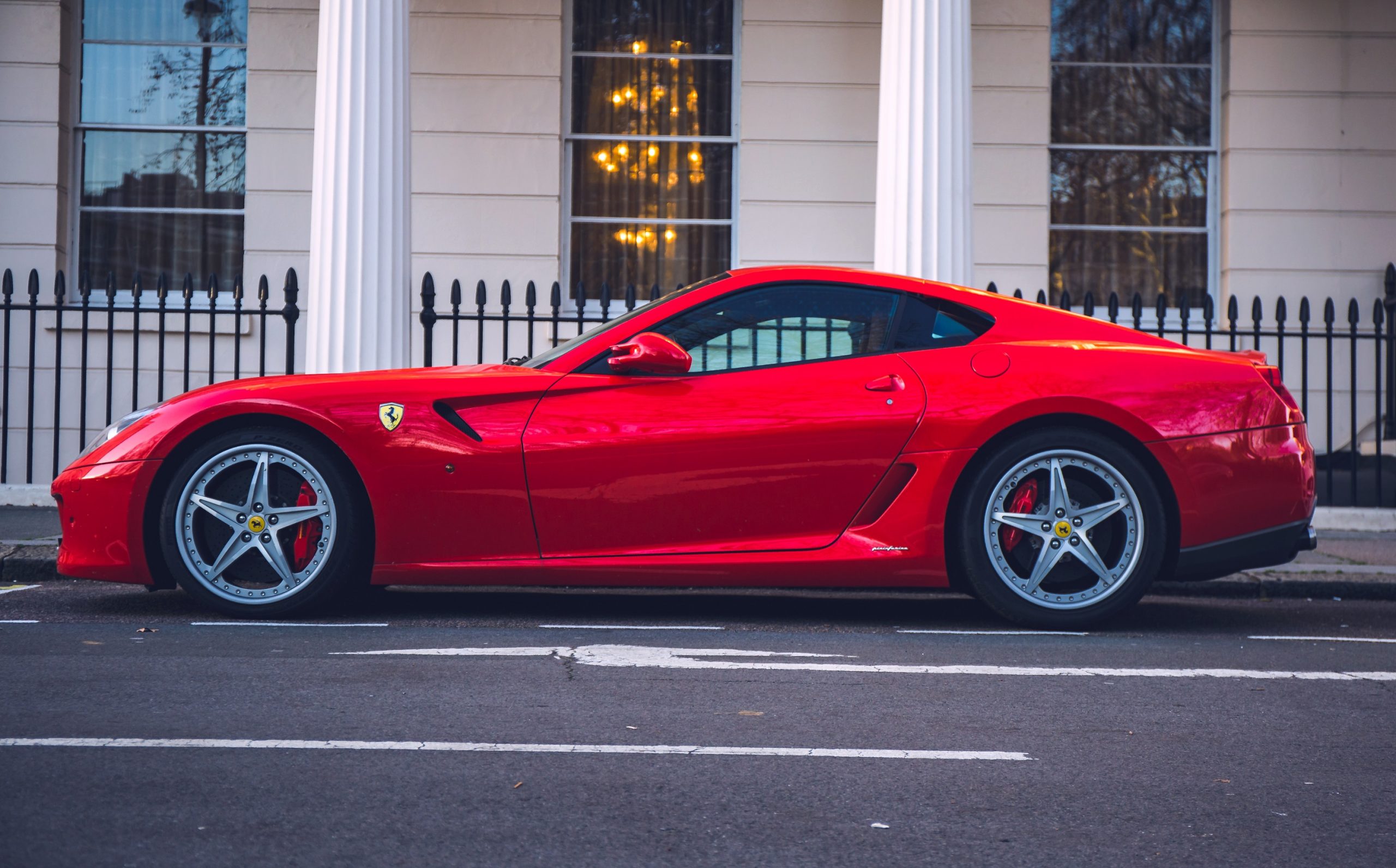 A red Ferrari 599 GTB shot in profile on a London side street